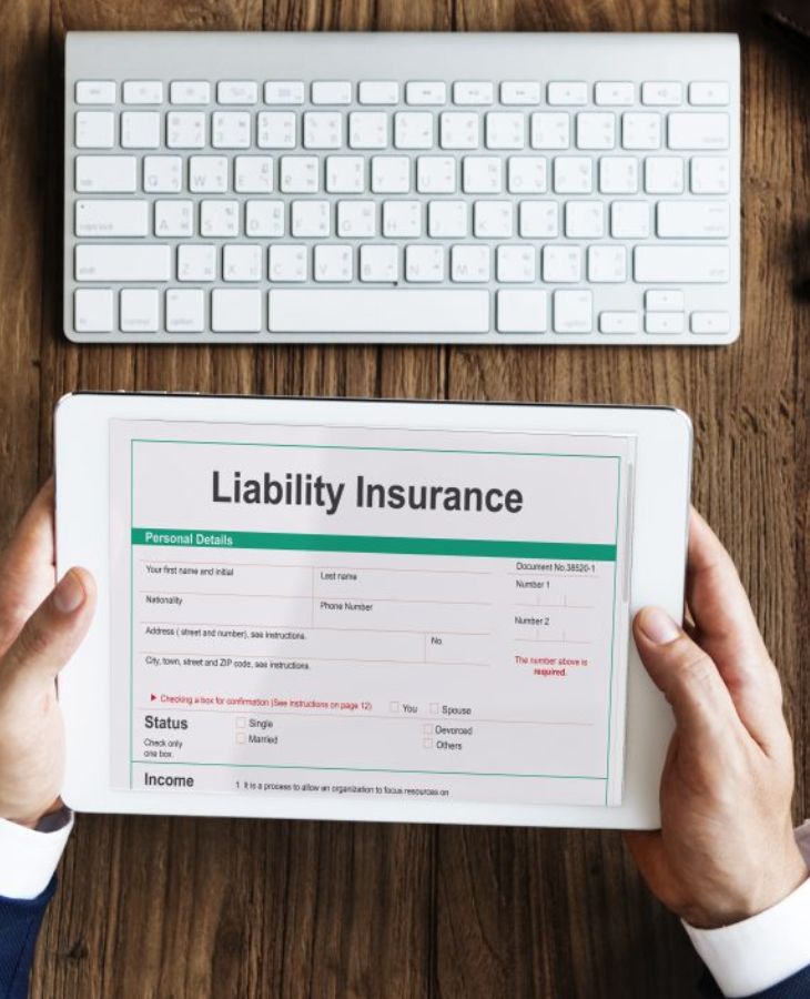 A Person Holding A Tab With Liability Insurance Form